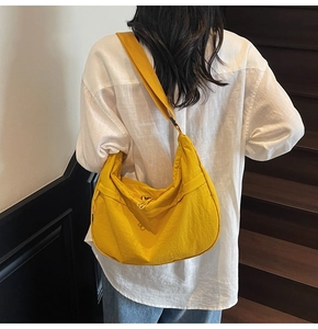 Gros plan du sac croissant jaune gingembre avec bandoulière réglable sur modèle