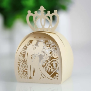 Detail of laser-cut wedding favor box with gold crown and romantic Mr & Mrs patterns