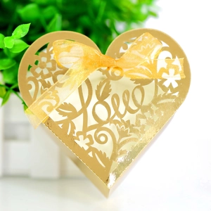 Detail of laser-cut heart candy box in gold finish with Love text and ribbon bow