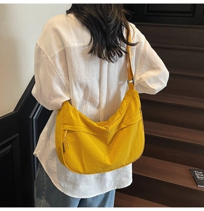 Vue détaillée du sac croissant en nylon jaune avec texture et bandoulière réglable