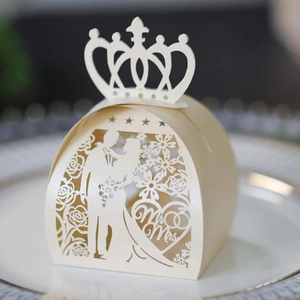 Macro detail of laser-cut wedding favor box with crown top and Mr & Mrs silhouette