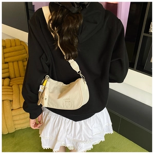Chic beige nylon crossbody crescent bag with embroidered logo on a stylish wide strap