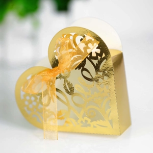 Detailed view of golden heart-shaped paper box with laser-cut Love text and elegant bow