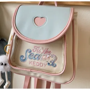 Detail of mini PU leather backpack with heart cutout, blue flap and letter embroidery