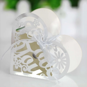 Close-up of heart-shaped hollow favor box with Thank You cutout and white ribbon