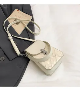 Detail of cream woven square bag showing texture, silver twist lock and dual straps