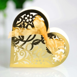 Detailed view of golden heart-shaped candy box with intricate laser-cut floral patterns and Love text