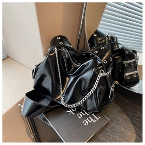 Detail of glossy black leather hobo bag with silver chain and eyelet strap accents