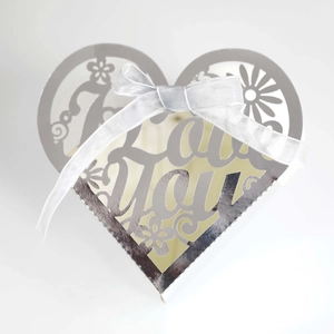 Detail of silver heart gift box with hollow Love You text and white satin ribbon