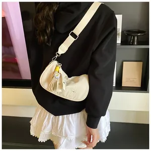 Detail of cream crescent crossbody bag with CHUU embossing and wide textile strap