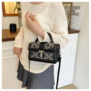 Close-up of ethnic geometric jacquard fabric and metal buckle on a square handbag