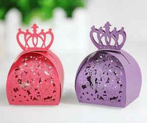 Close-up of laser-cut flower patterns and crown design on red and purple candy boxes
