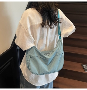 Vue détaillée du sac croissant bleu lac avec texture plissée et large bandoulière