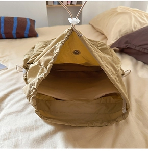 Vue détaillée du sac à dos à cordon kaki avec boutons-pression en métal et intérieur large