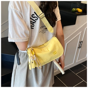 Bright yellow nylon half-moon crossbody bag with wide strap and brand logo detail