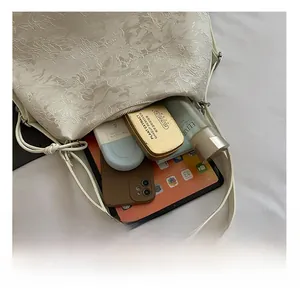 Detail view of large white floral jacquard bag capacity with tablet and daily essentials