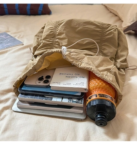 Détail du sac à dos kaki en nylon avec fermeture à cordon et grande capacité de rangement