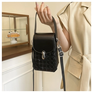 Detail of black mini crossbody bag featuring a woven texture and silver metal clasp