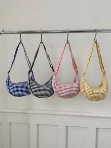 Detailed display of gingham crescent bags in blue, black, pink and yellow canvas colors
