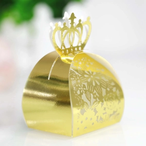 Detailed close-up of a laser-cut gold crown candy box with intricate floral hollow patterns