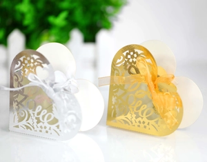 Detail of laser-cut heart candy boxes with LOVE pattern and elegant ribbon bows