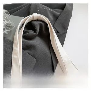 Detail shot of a white leather wide handle with refined stitching for a tote bag