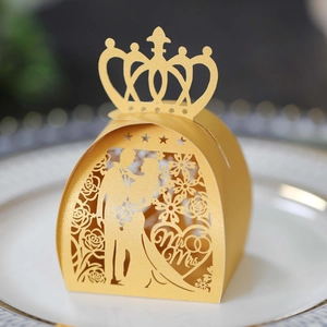 Close-up of laser-cut gold wedding favor box featuring crown and Mr & Mrs design
