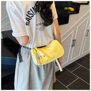 Rear view of a yellow pleated nylon crescent bag worn by a model in a stairwell