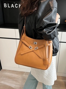 Classic caramel crossbody bucket bag with decorative cross-straps and silver metal twist lock