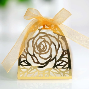 Dettaglio della scatola di caramelle rosa dorata tagliata al laser con fiocco in organza