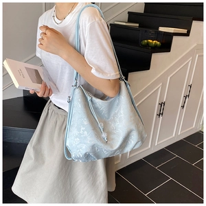 Close-up of light blue embroidered tote bag with textured cloud floral pattern details