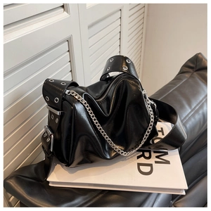 Detail of glossy black shoulder bag with silver chain and wide grommet strap