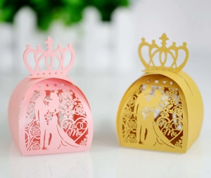 Detail of laser cut wedding candy boxes with Mr & Mrs silhouette and gold crown top