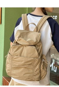 Détail du sac à dos en nylon kaki avec poches à cordon et tissu à texture gaufrée