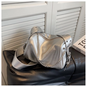 Detail of silver metallic wrinkled texture bag with chic chain and metal grommet strap