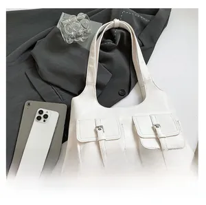 White minimalist shoulder bag with dual front pockets and silver buckle hardware details