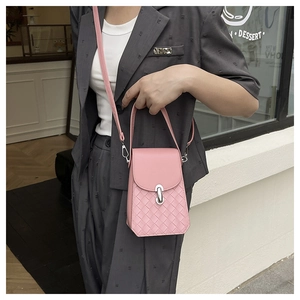 Detailed close-up of pink woven leather shoulder bag with oval silver metal clasp