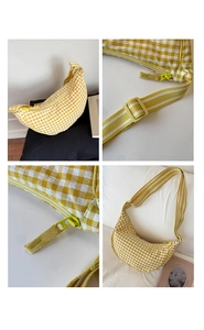 Detailed close-up of yellow checkered canvas dumpling bag with adjustable strap and zipper