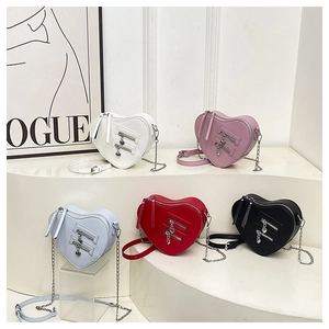 Detailed view of heart-shaped crossbody chain bags in white, pink, blue, red and black