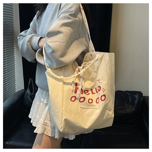 Detail of floral lining and red Hello print on a cream canvas tote bag with side view