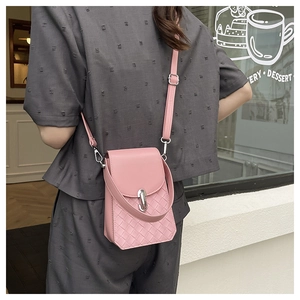 Detailed view of pink crossbody bag featuring woven embossed texture and metal clasp