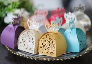 Macro detail of laser-cut crown candy boxes with intricate floral hollow patterns