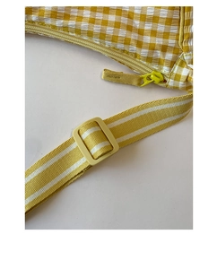 Close-up of yellow checkered seersucker fabric bag with plastic buckle and zipper
