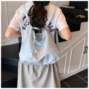 Detail of light blue embroidered backpack with floral texture and drawstring closure