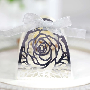 Dettaglio scatola regalo rosa tagliata al laser argento con nastro di seta bianco su vassoio