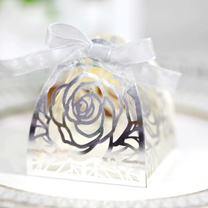 Dettaglio macro di rose intagliate al laser su scatola regalo d'argento con fiocco bianco