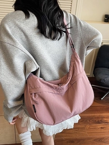 Sac bandoulière demi-lune rose avec sangle large et poche latérale zippée