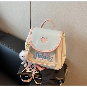 Close-up of cute mini backpack with heart cutout and white plush pendant detail