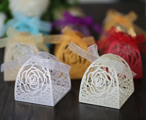 Dettaglio delle scatole per bomboniere tagliate al laser con rose e nastri colorati