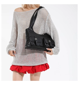 Detail of black faux leather shoulder bag featuring cargo pockets and silver buckles